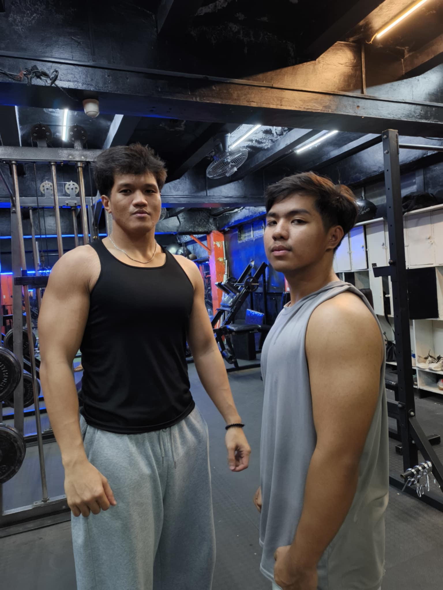 Two lifters flexing in black tanks