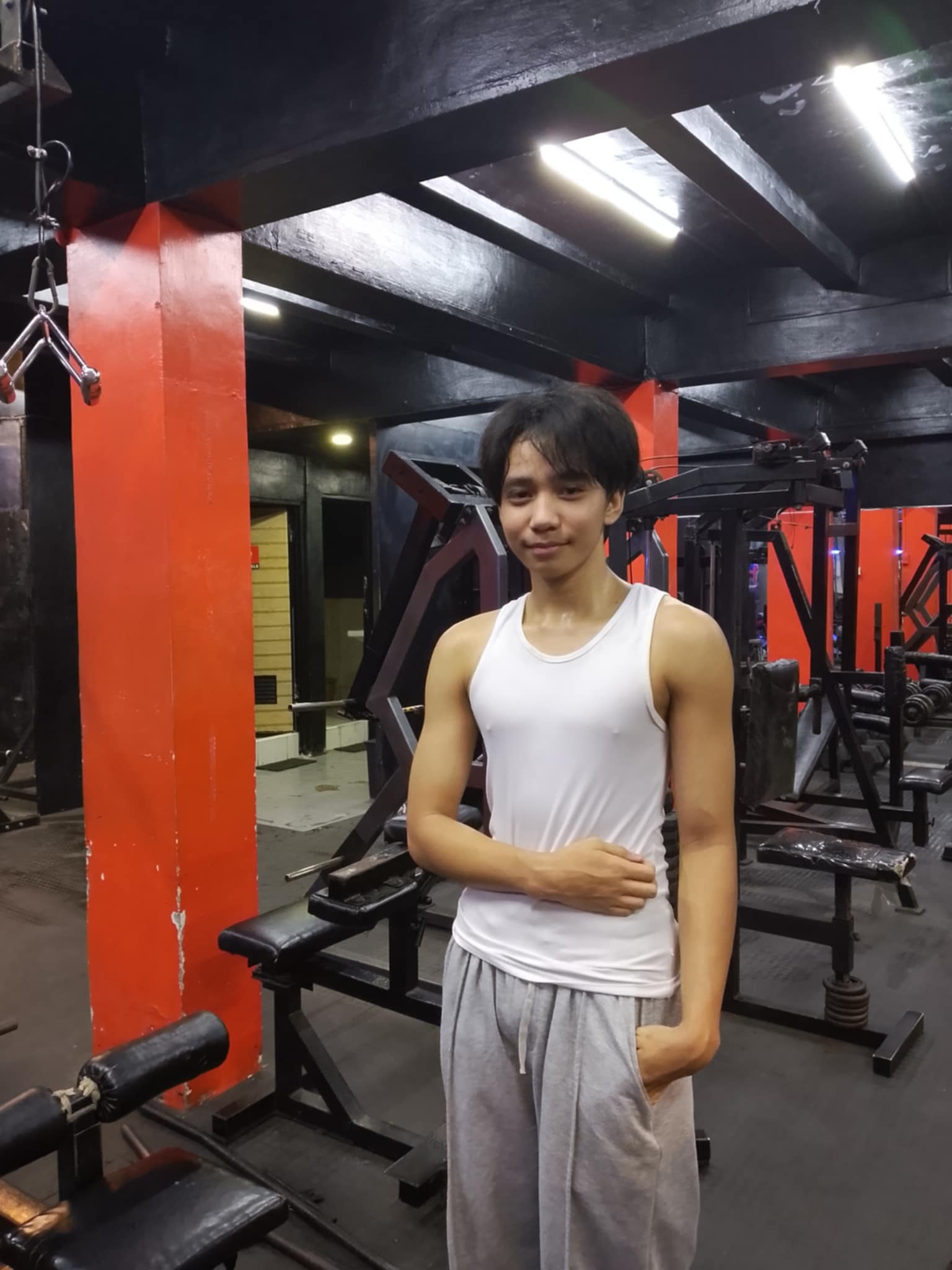 Guy in white tank top flexing