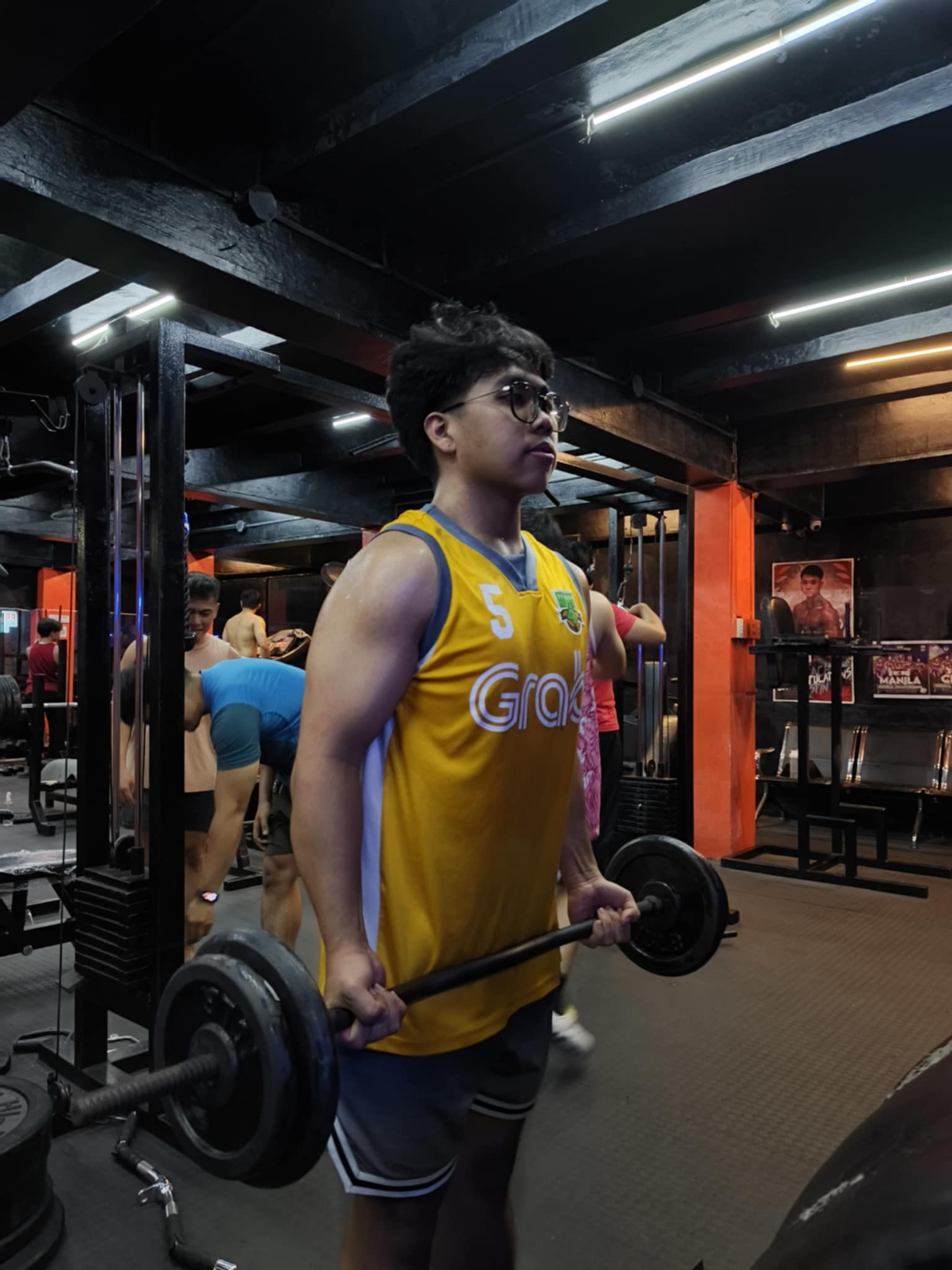 Lifter in yellow jersey doing deadlift
